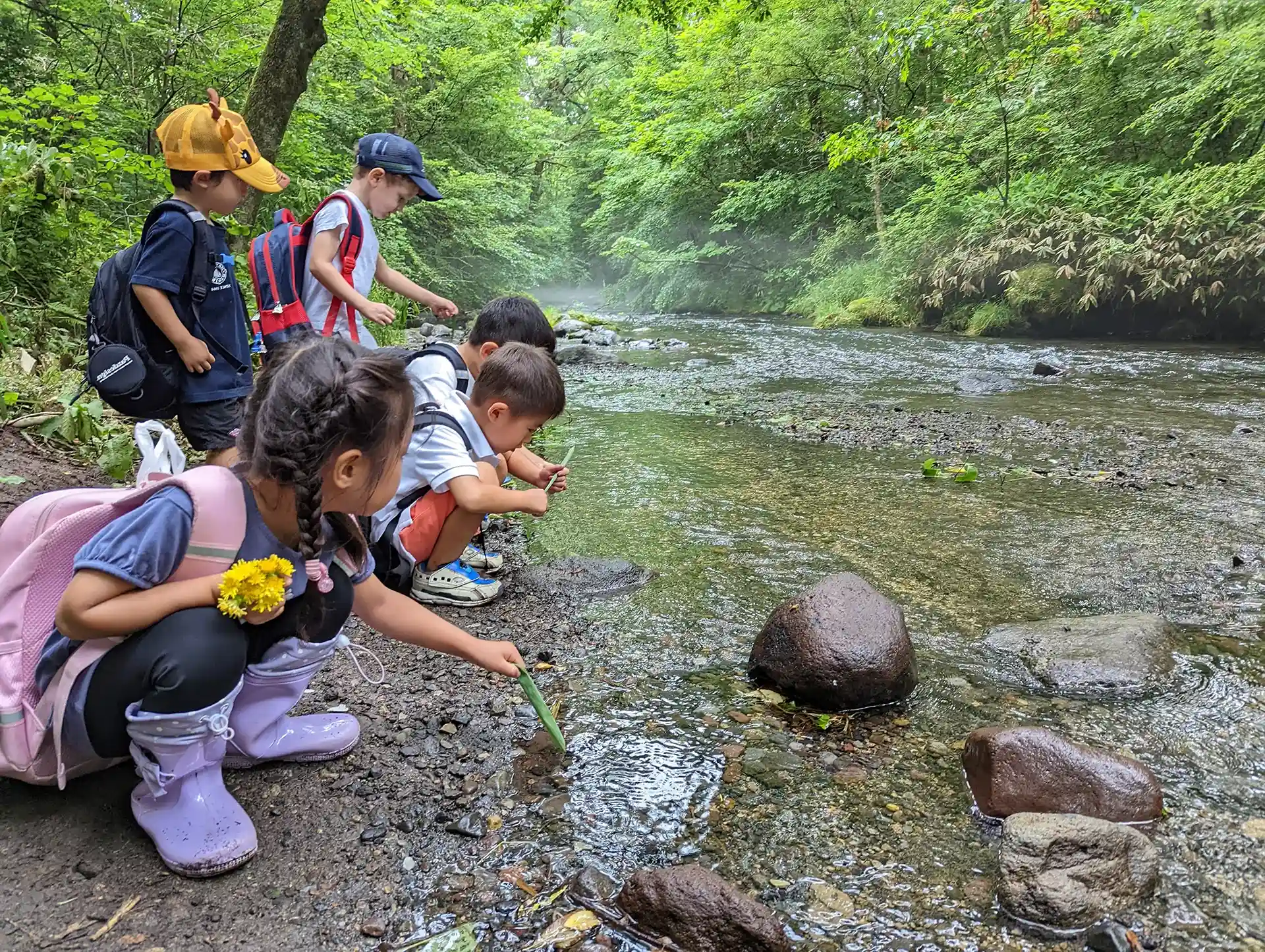 iforest International School Japan students play by the river.