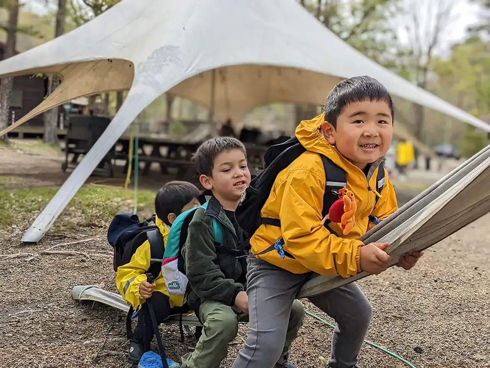 Friends playfully gather on one corner of the camp tarp, having a great time together. Laughter and smiles abound as they engage in fun activities, enjoying each other's company. Their playful energy brings a lively and joyful atmosphere to the campsite, creating lasting memories of friendship and adventure.